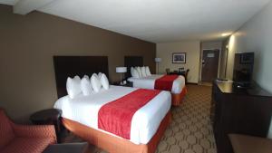 a hotel room with two beds and a chair at Best Western Palmyra Inn & Suites in Palmyra