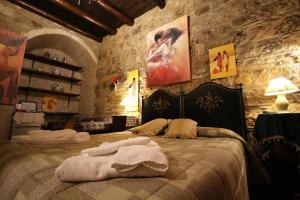 a bedroom with a large bed in a stone wall at Kimera in Piazza Armerina