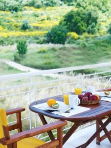 a table with a basket of fruit and orange juice at Muses Studios Sami in Sami