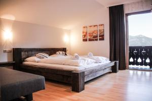 a bedroom with a large bed and a large window at Apartment Bauernhof Birkhöfl by we rent in Zell am See