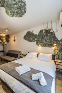 a bedroom with a large bed with towels on it at GraffitiSuites#Stone in Thessaloniki