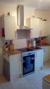 a kitchen with white cabinets and an oven at Heart of Filey in Filey