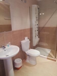
a white toilet sitting next to a sink in a bathroom at Hotel Gardu in Montealegre del Castillo

