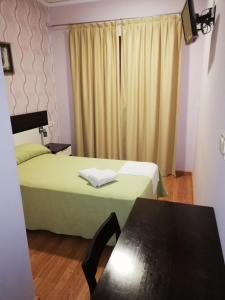 Habitación con 2 camas, mesa y ventana en Hotel Gardu, en Montealegre del Castillo