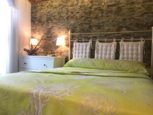 1 dormitorio con cama verde y pared de ladrillo en Casa con encanto en Calabardina, cerca de la playa, en Calabardina