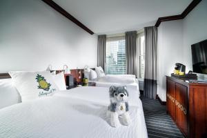 a hotel room with two beds with a stuffed dog on the bed at Staypineapple, An Iconic Hotel, The Loop in Chicago
