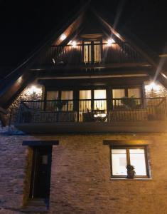 a house with a balcony on the side of it at night at Apartament Casa Rey in Vilac