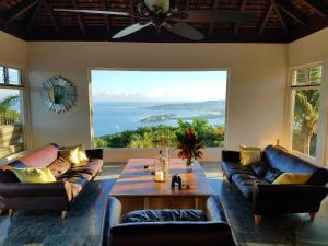 a living room with couches and a table and a large window at Waterfield Villa in Montego Bay