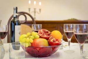 a bowl of fruit on a table with wine glasses at Vittoria Street Charming in Rome
