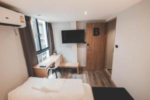 チェンマイにあるStay Thapae Hostelのベッドと机とパソコンが置かれたホテルの部屋