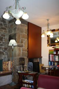 a living room with a stone fireplace and a chandelier at Hotel Cenera in Cenera