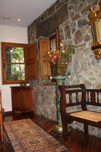 Habitación con una pared de piedra y un jarrón con flores. en Hotel Cenera, en Cenera