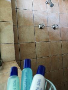 three bottles of water sitting on the floor in a shower at Kloofsig Holiday Cottages in Graskop