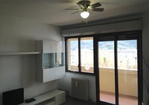 un soggiorno con ventilatore a soffitto e 2 finestre di Raggio di Sole a Sestri Levante
