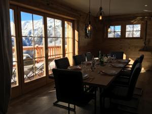 een eetkamer met een tafel en stoelen en uitzicht op de bergen bij Chalet l'Ardoisière in Villard-Reculas
