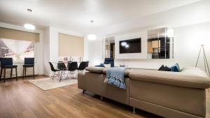 a living room with a couch and a dining room at Dumbrava Residence in Sibiu