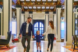 Una famiglia che cammina lungo un corridoio con un bambino che si tiene per mano di Hotel Spero a San Francisco