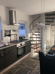 a kitchen with black cabinets and a spiral staircase at Ferienhaus Eichhorn in Breege