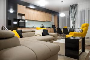 a living room with two couches and a kitchen at Dumbrava Residence in Sibiu