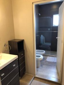 a bathroom with a toilet and a glass shower at Aires de Río in Bella Vista