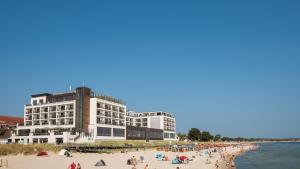 a large building on a beach with people on it at Bayside in Scharbeutz