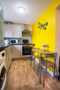 a kitchen with a table and a butterfly on the wall at Ripley Peak District Gateway in Ripley