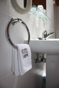 ein Handtuch auf einem Regal neben einem Waschbecken in der Unterkunft Hotel Cenera in Cenera