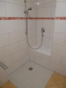 ゾントホーフェンにあるAuszeit im Allgäuの白いタイル張りのバスルーム(シャワー、ホース付)