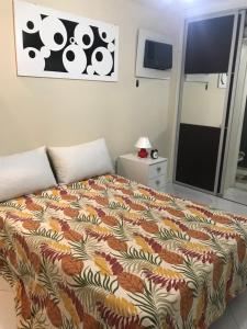 1 dormitorio con 1 cama con una manta colorida en Apart KING BARRA, en Salvador
