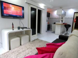 sala de estar con sofá y TV en la pared en Apart KING BARRA, en Salvador