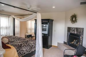 1 dormitorio con 1 cama con chimenea y TV en Slot Canyons Inn Bed & Breakfast, en Escalante