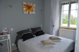 a bedroom with a white bed with pillows and a window at Domaine de Chantegros in Eyzerac