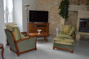 Eyzerac的住宿－Domaine de Chantegros，客厅配有两把椅子和电视