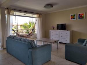 una sala de estar con 2 sofás azules y una mesa. en AP CONFORTAVEL NA PRAIA DO FUTURO FORTALEZA DE 150m 3 QUARTOS 2 SUITES PARA 12 PESSOAS, en Fortaleza