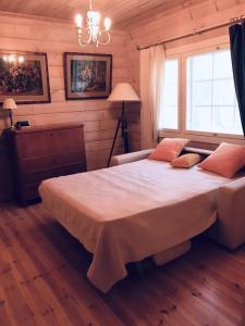 um quarto com uma cama grande num quarto de madeira em Big Cottage By The Lake em Kerimäki