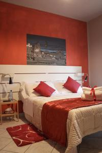 1 dormitorio con 2 camas y paredes de color rojo en B&B del Viale, en LʼAquila
