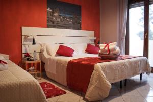 a bedroom with a large bed with red walls at B&B del Viale in LʼAquila