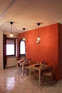 a dining room with red walls and wooden tables at B&B del Viale in LʼAquila