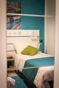 1 dormitorio con cama blanca y almohada verde en B&B del Viale, en LʼAquila