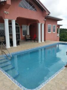 a swimming pool in front of a house at PARADISE on the Isle of Spice in Calivigny