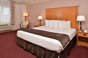 una camera d'albergo con un grande letto e una finestra di Stage Coach Inn a West Yellowstone