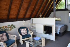 sala de estar con 2 sillas y chimenea en Coastal Motor Lodge, en Thames