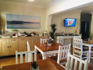a dining room with a table and a kitchen at PepperTree Guest House Paulshof Jhb Sandton Solar&Borehole in Johannesburg