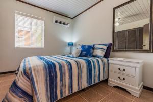 Schlafzimmer mit einem Bett und einem Spiegel in der Unterkunft Old Aloe House in Savaneta