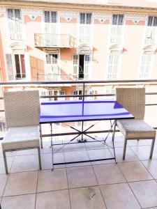 a blue table and two chairs on a balcony at Portobello residence in Nice