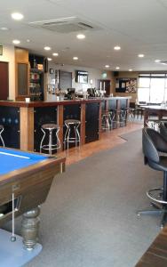 a pool table in a library with bar stools at Catlins Inn in Owaka