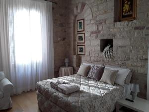 una camera da letto con un letto grande e un muro di pietra di Suite Assisi ad Assisi