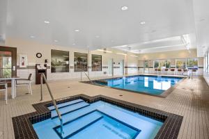 a large swimming pool in a large room with a pool at Mountain View Inn & Suites in Sundre