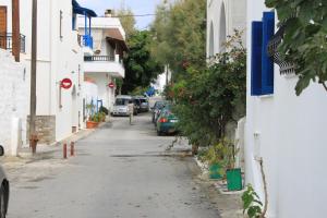 an empty street with cars parked on the side of a building at Vasilikos Studios in Naxos Chora