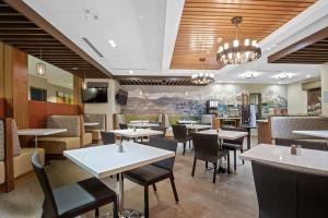 a dining room with tables and chairs in a restaurant at Mountain View Inn & Suites in Sundre